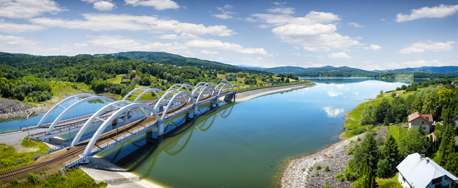 Lac Mucharskie en Pologne, avec ponts routiers et ferroviaires sur la rivière Skawa. © iStock / ewg3D