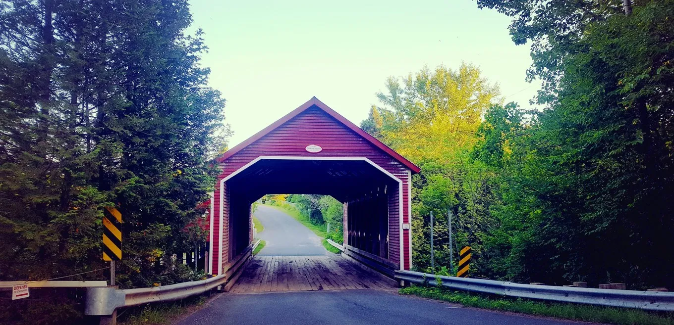 Vue du pont couvert au toit rouge sur le chemin Porter à Ulverton près du moulin à laine dans les Cantons de l'Est au Québec. © iStock / Pierre-Olivier Valiquette